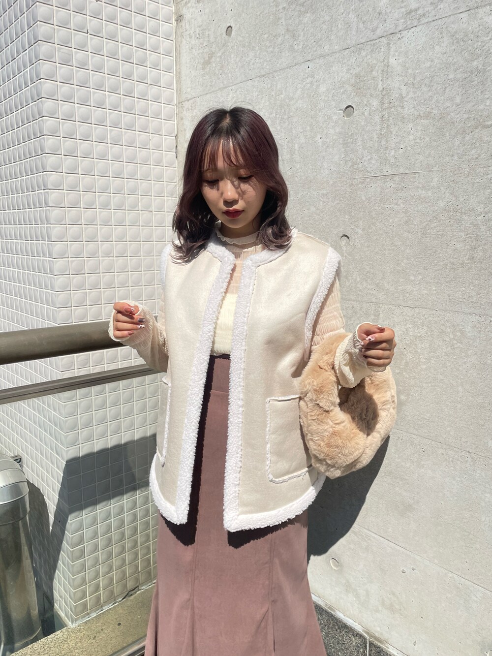 ホワイト系のベスト、ホワイト系のTシャツ/カットソー、ベージュ系のバッグを着用したレディースの秋コーディネートの3枚目の写真