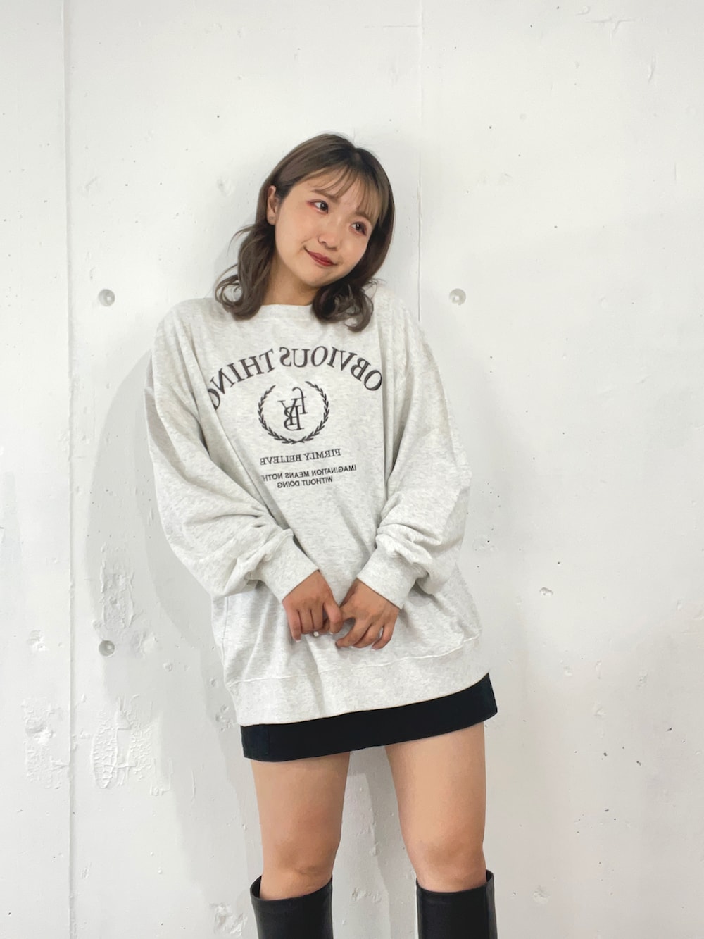 グレー系のスウェット、ブラック系のスカート、ブラック系のブーツを着用したレディースの秋コーディネートの4枚目の写真