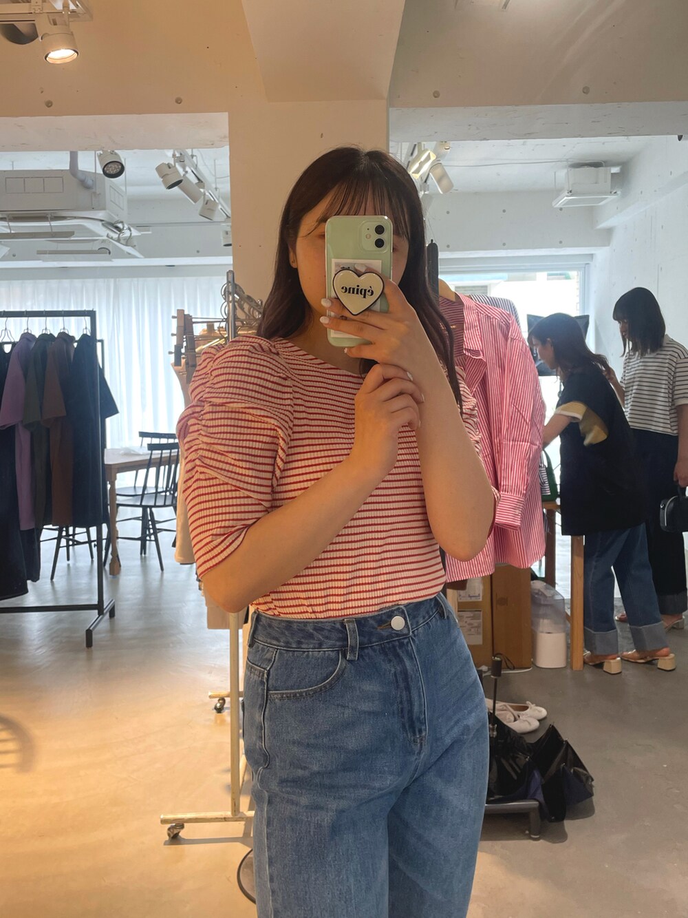 レッド系のTシャツ/カットソー、ブルー系のデニムパンツ、ベージュ系のシューズを着用したレディースの夏コーディネートの2枚目の写真