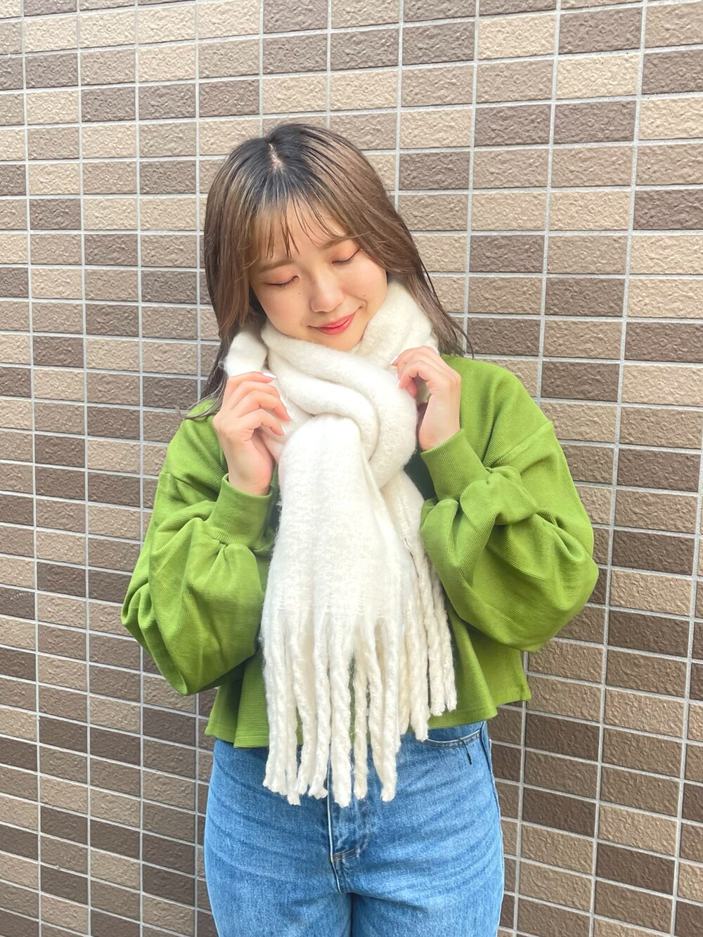 グリーン系のカーディガン/ボレロ、ブルー系のデニムパンツ、ゴールド系のバレエシューズを着用したレディースの秋コーディネートの2枚目の写真