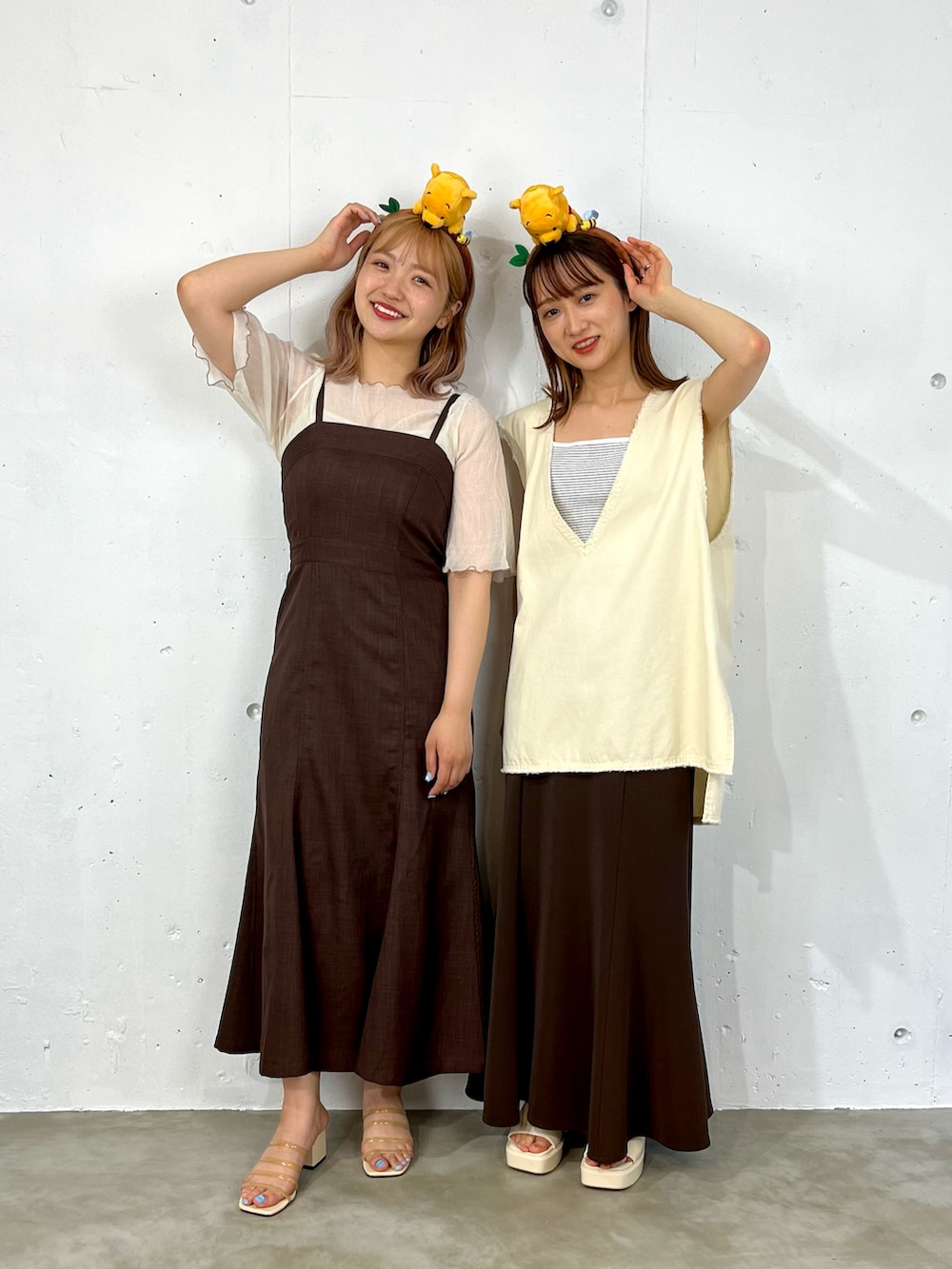 ホワイト系のシャツ/ブラウス、ブラウン系のジャンパースカート、ベージュ系のサンダルを着用したレディースの夏コーディネートの2枚目の写真