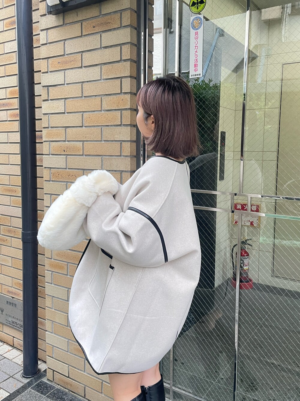 ホワイト系のその他アウター、グレー系のニット/セーター、ホワイト系のスカートを着用したレディースの秋コーディネートの3枚目の写真