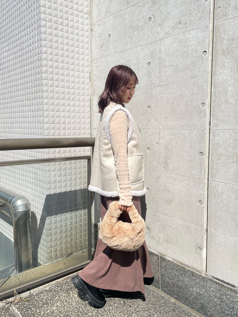 ホワイト系のベスト、ホワイト系のTシャツ/カットソー、ベージュ系のバッグを着用したレディースの秋コーディネートの2枚目の写真