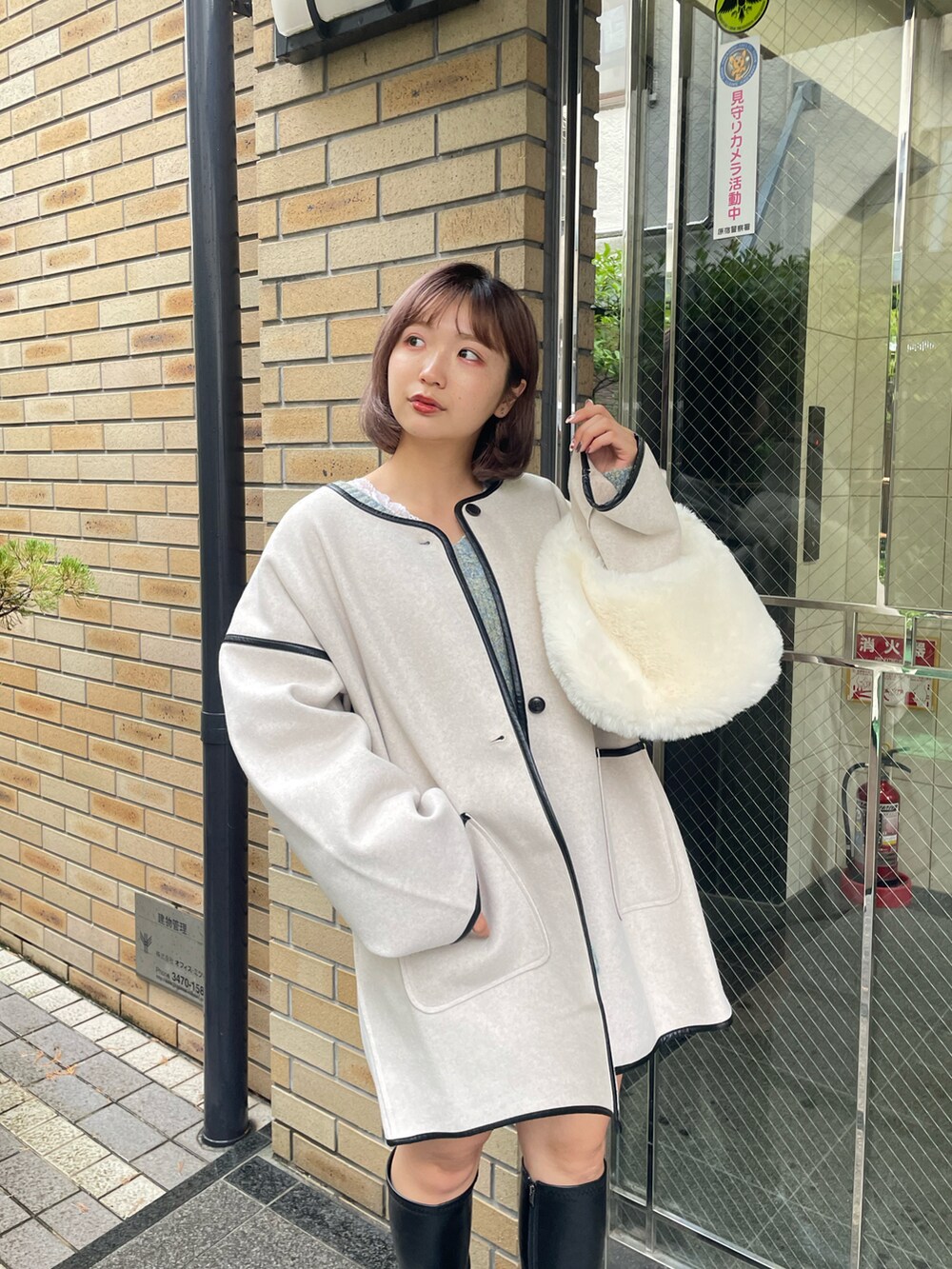 ホワイト系のその他アウター、グレー系のニット/セーター、ホワイト系のスカートを着用したレディースの秋コーディネートの2枚目の写真