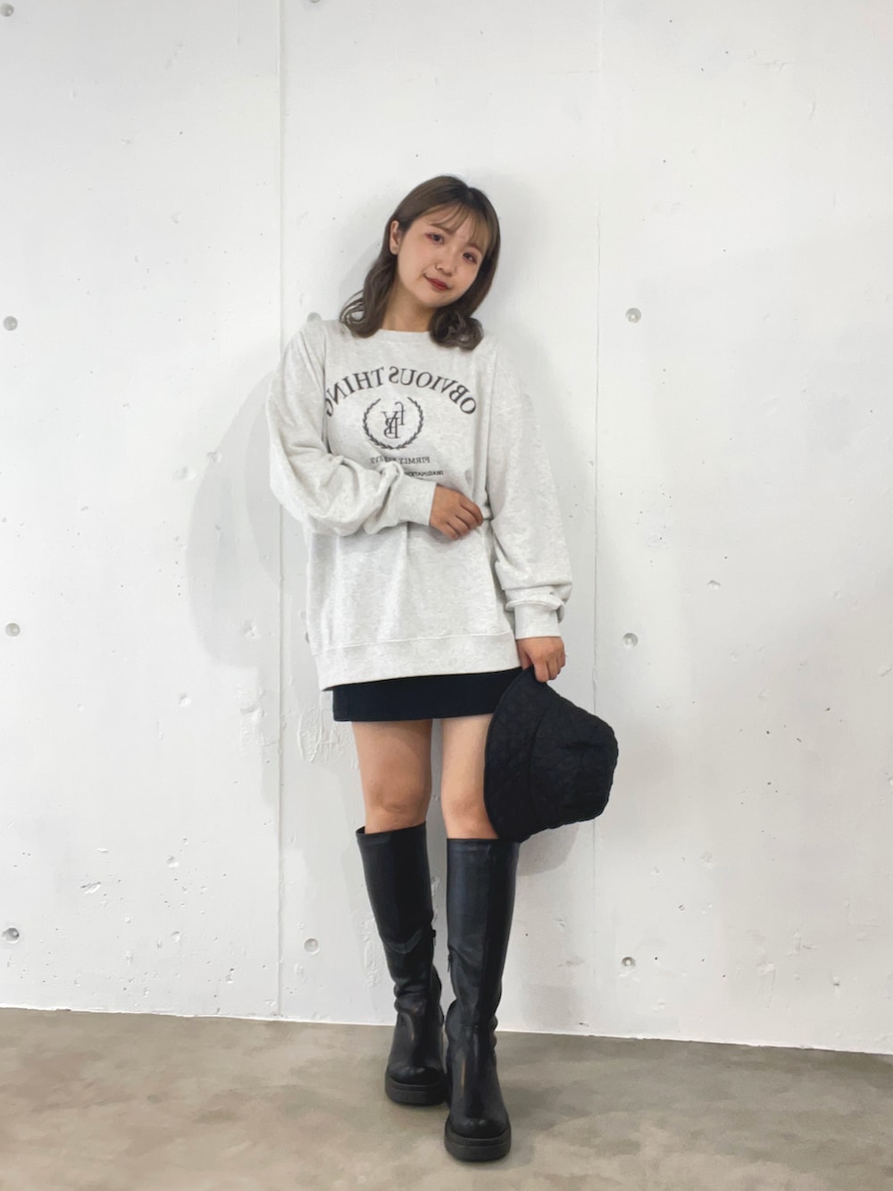 グレー系のスウェット、ブラック系のスカート、ブラック系のブーツを着用したレディースの秋コーディネートの2枚目の写真