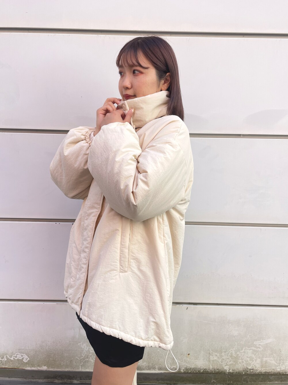 ホワイト系のブルゾン、ブラック系のスカート、ホワイト系のブーツを着用したレディースの冬コーディネートの4枚目の写真