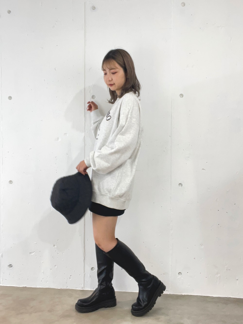 グレー系のスウェット、ブラック系のスカート、ブラック系のブーツを着用したレディースの秋コーディネートの3枚目の写真