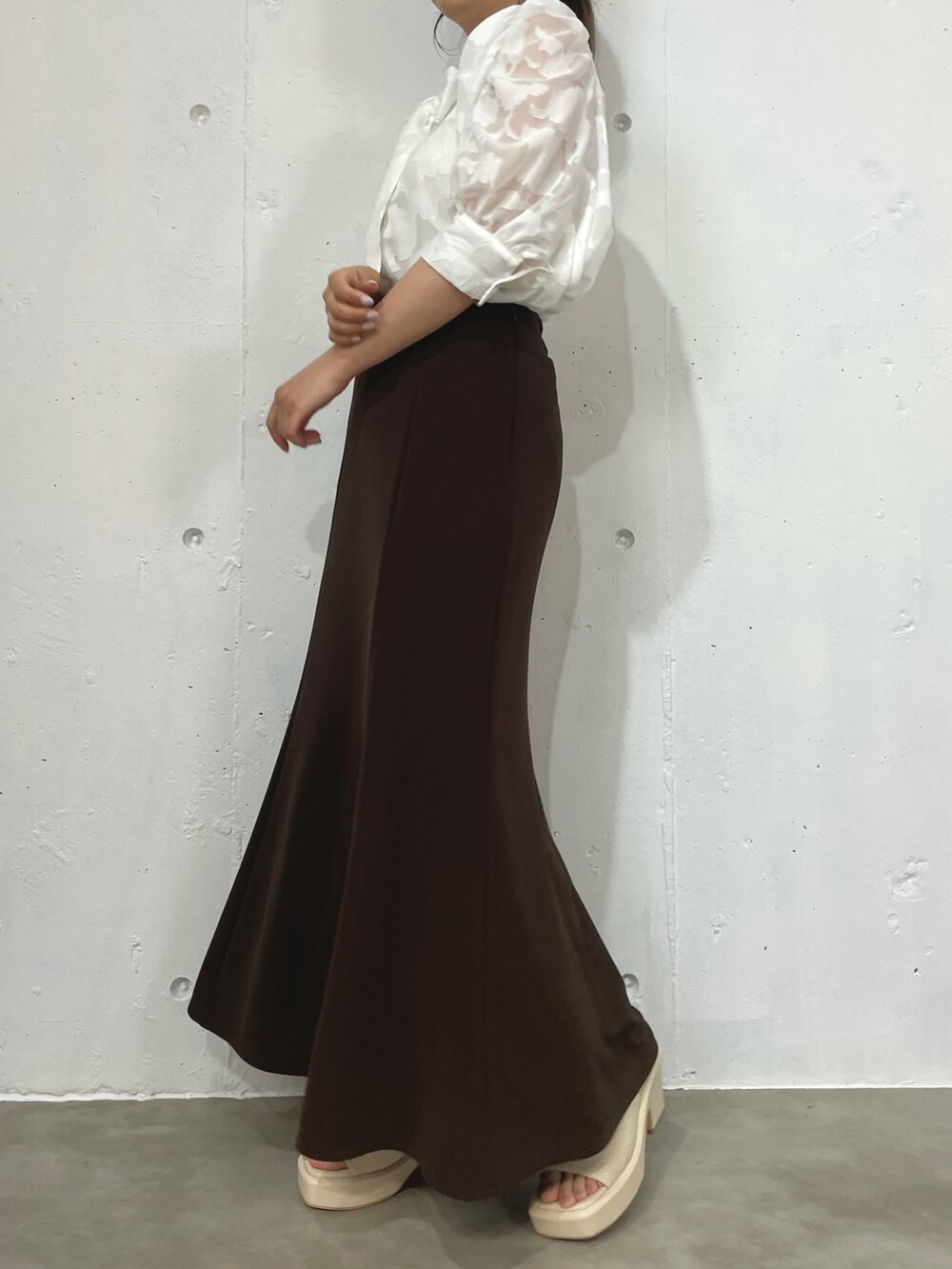 ホワイト系のシャツ/ブラウス、ブラウン系のスカート、ホワイト系のサンダルを着用したレディースの夏コーディネートの2枚目の写真