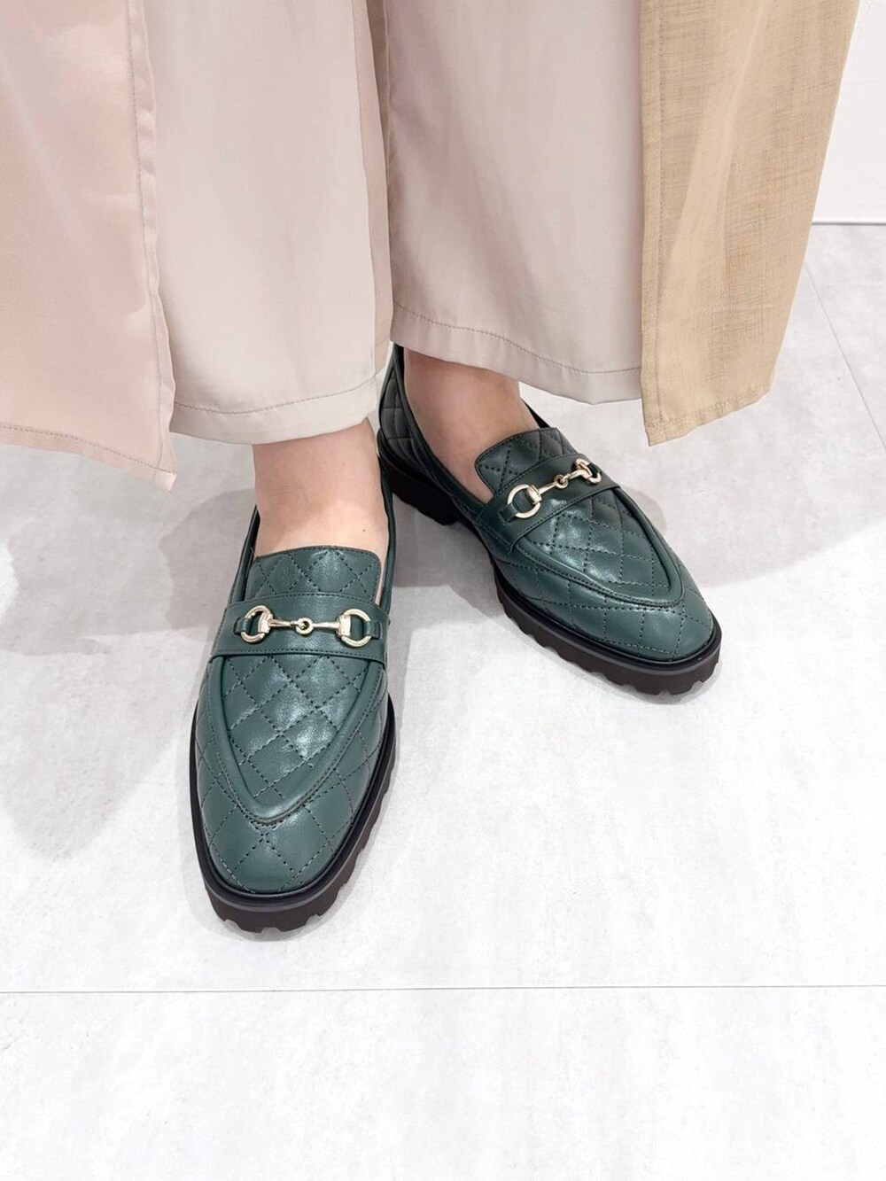 グリーン系のローファーを着用したレディースの秋コーディネートの5枚目の写真