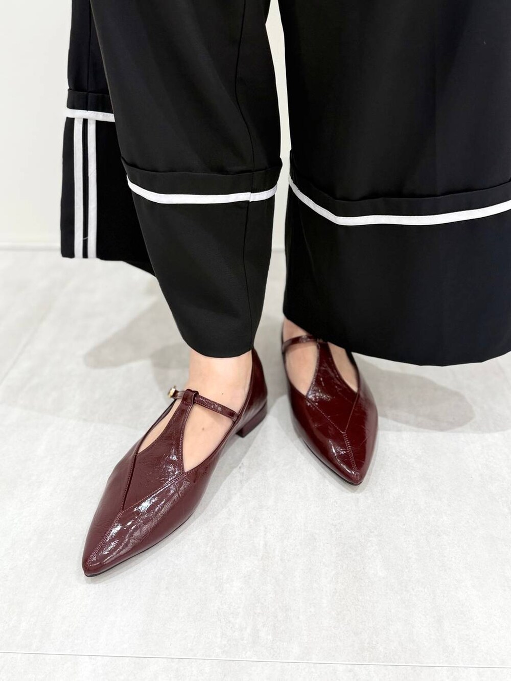 レッド系のパンプスを着用したレディースの秋コーディネートの4枚目の写真