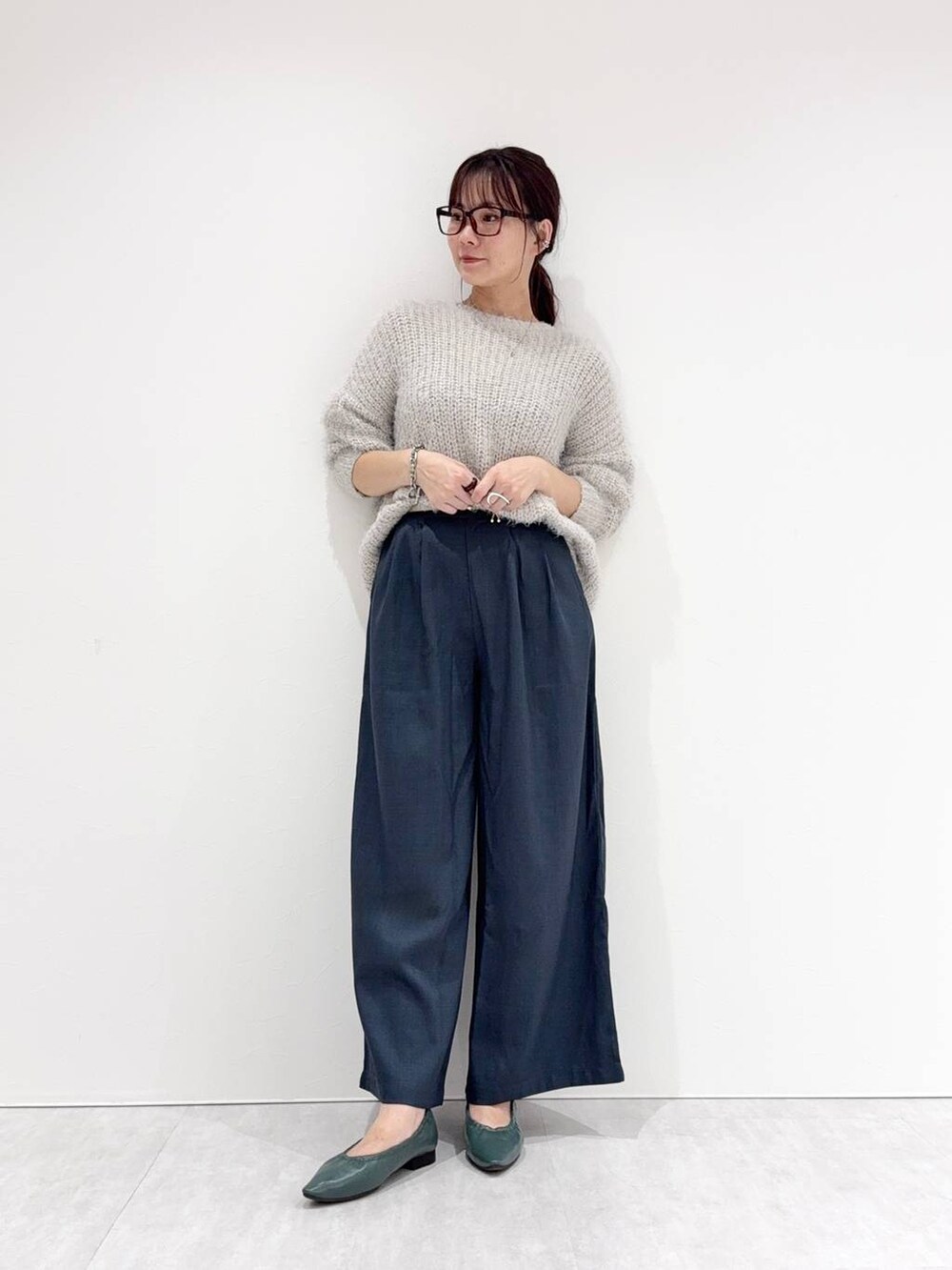 グリーン系のパンプスを着用したレディースの秋コーディネートの2枚目の写真