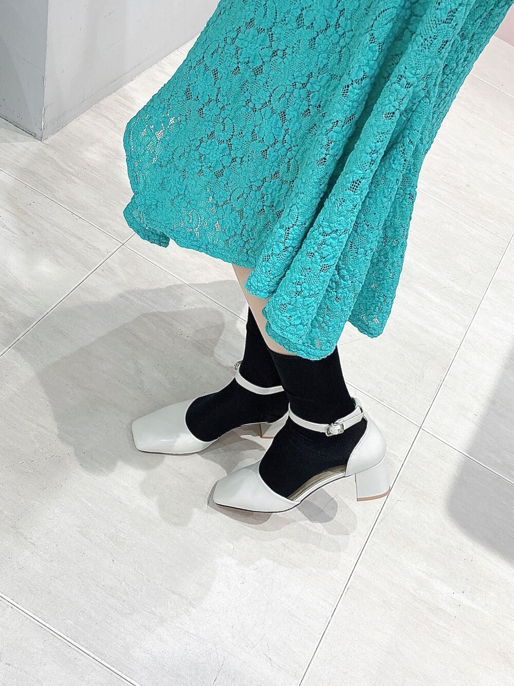 ホワイト系のパンプス、グリーン系のワンピースを着用したレディースの春コーディネートの2枚目の写真