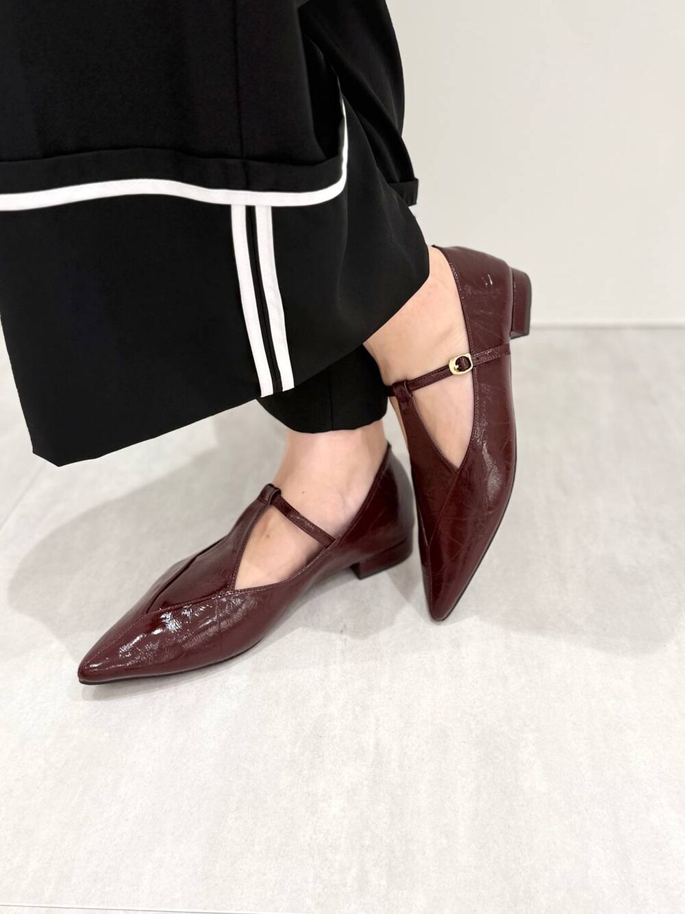 レッド系のパンプスを着用したレディースの秋コーディネートの5枚目の写真