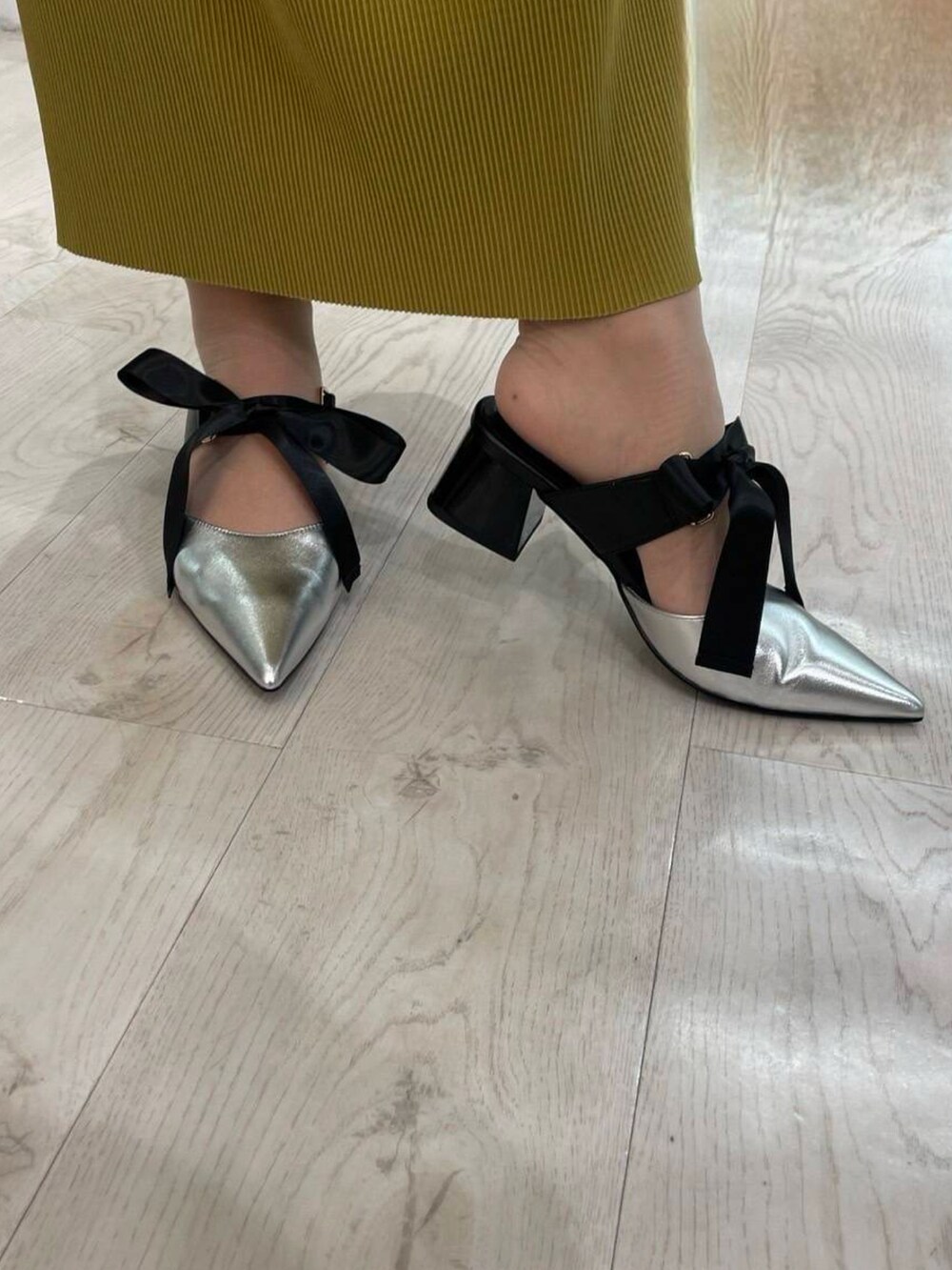 シルバー系のパンプス、イエロー系のスカート、ブルー系のシャツ/ブラウスを着用したレディースの春コーディネートの2枚目の写真