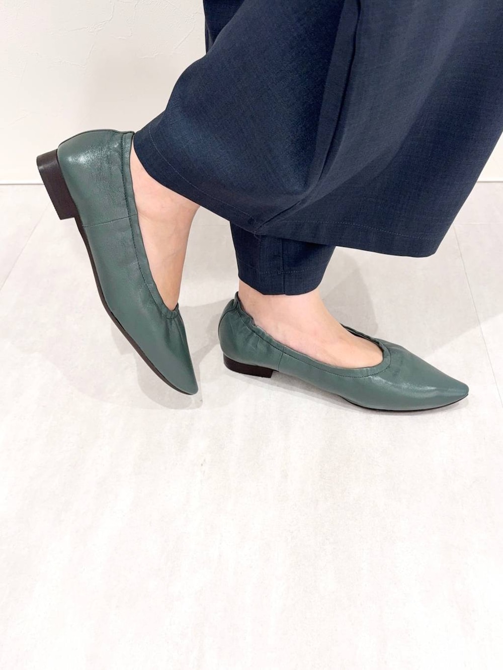 グリーン系のパンプスを着用したレディースの秋コーディネートの5枚目の写真