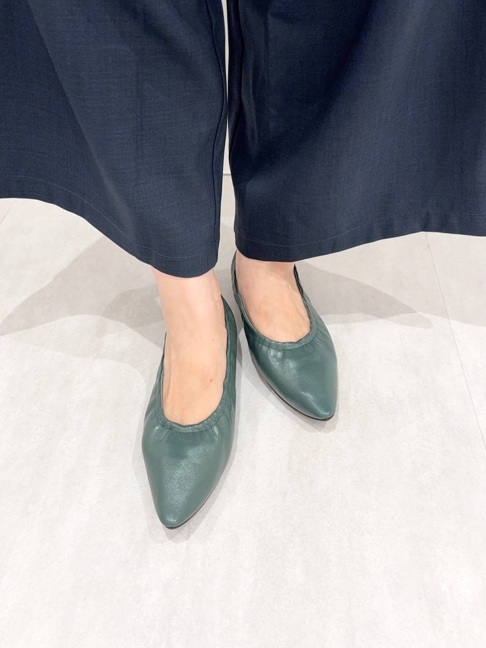 グリーン系のパンプスを着用したレディースの秋コーディネートの4枚目の写真