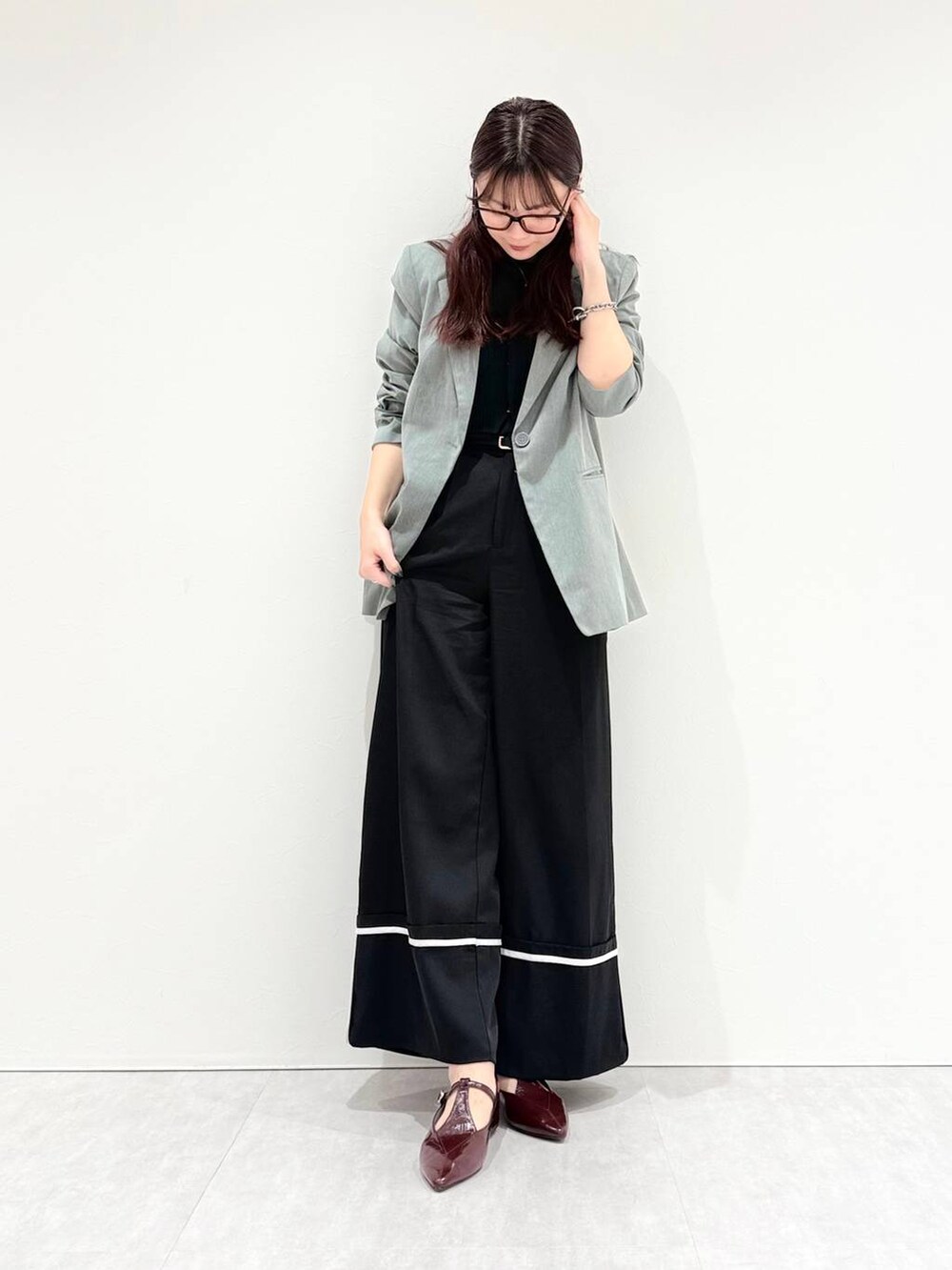 レッド系のパンプスを着用したレディースの秋コーディネートの3枚目の写真