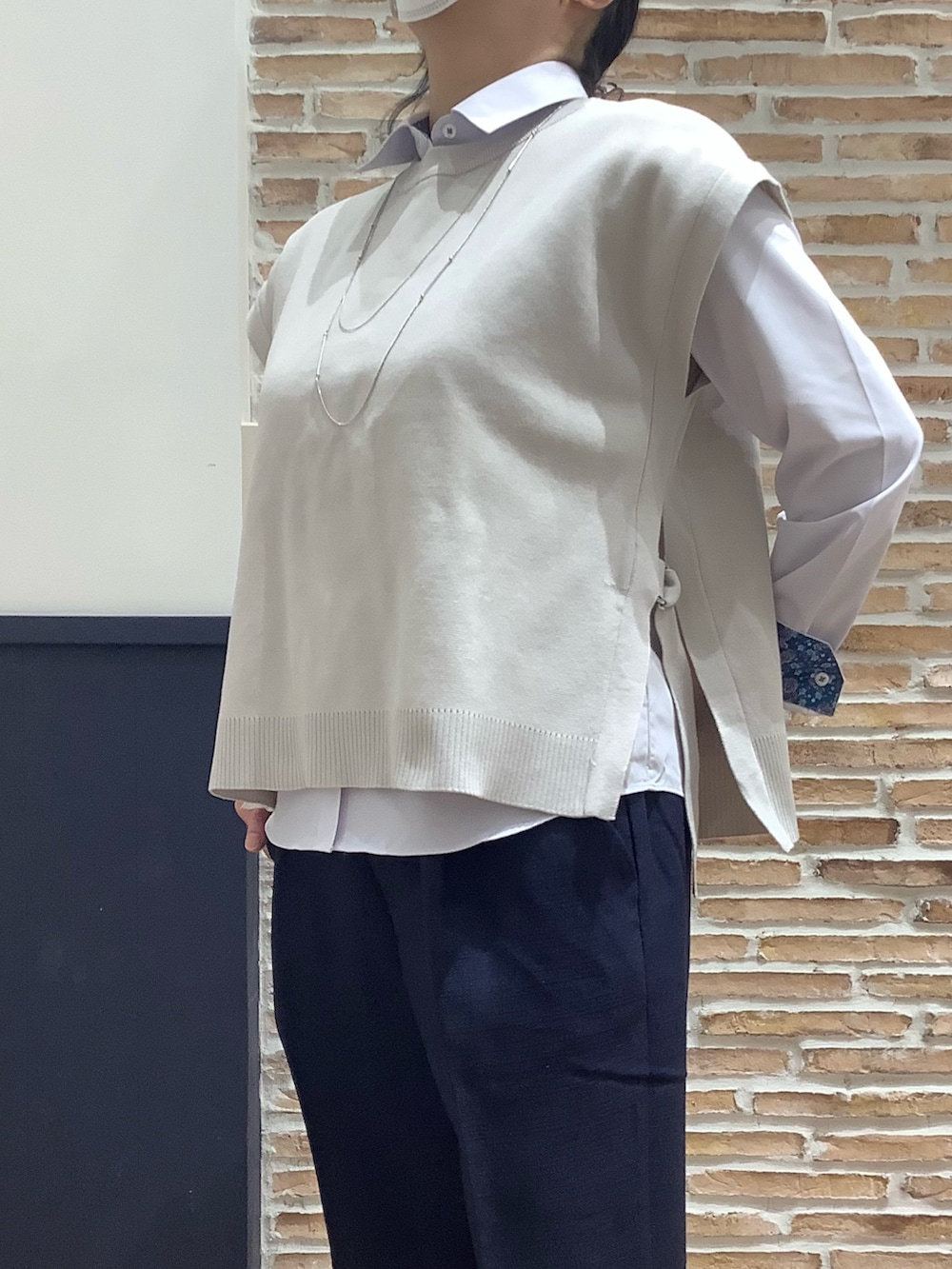 ブルー系のスラックス、パープル系のシャツ/ブラウス、ホワイト系のベストを着用したレディースの冬コーディネートの2枚目の写真