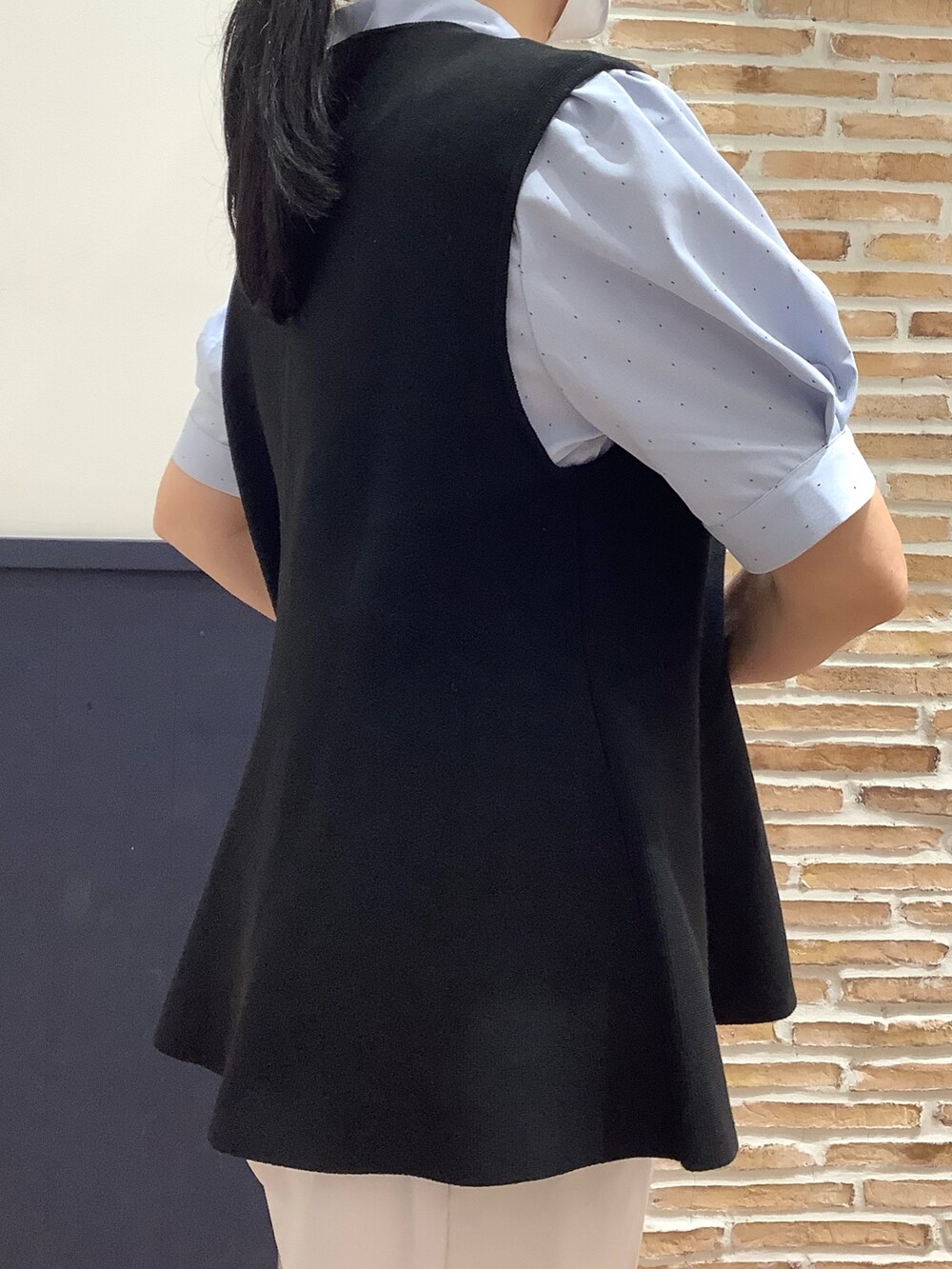 ブラック系のベスト、ブルー系のシャツ/ブラウス、ホワイト系のパンツを着用したレディースの夏コーディネートの7枚目の写真