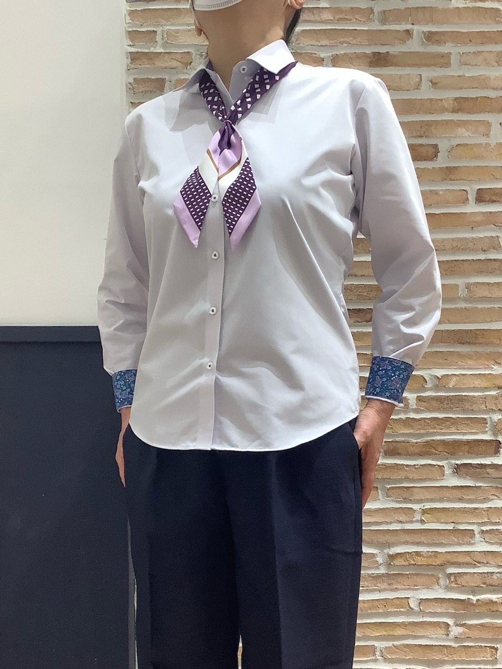 ブルー系のスラックス、パープル系のシャツ/ブラウス、ホワイト系のベストを着用したレディースの冬コーディネートの4枚目の写真