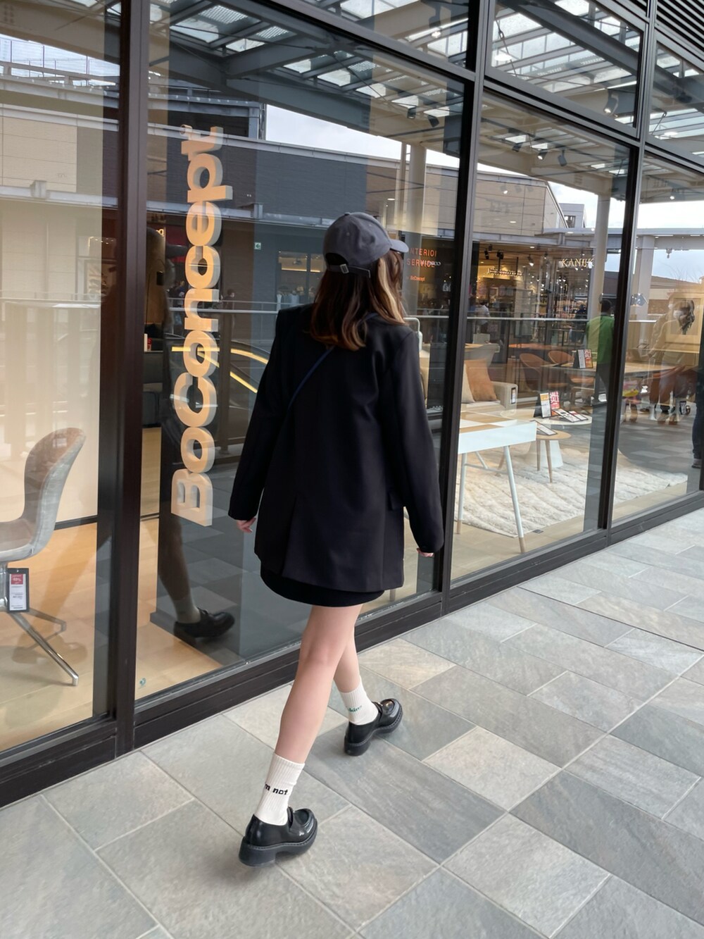 ブラック系のTシャツ/カットソー、ブラック系のスカート、ブラック系のローファーを着用したレディースの春コーディネートの4枚目の写真