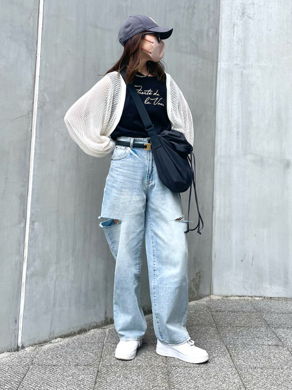 ブルー系のデニムパンツ、ブラック系のバッグ、ブラック系のTシャツ/カットソーを着用したレディースの春コーディネートの3枚目の写真