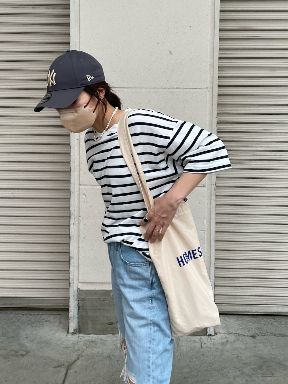 ブルー系のデニムパンツ、ブルー系のTシャツ/カットソー、ホワイト系のトートバッグを着用したレディースの夏コーディネートの4枚目の写真