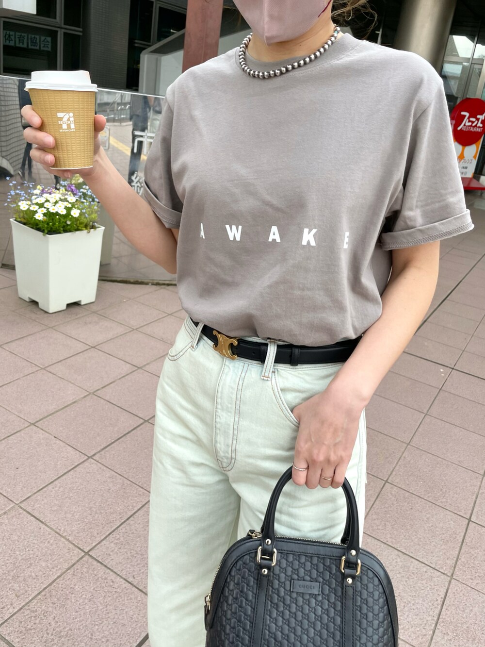 ブルー系のデニムパンツ、ベージュ系のTシャツ/カットソー、ブラック系のバッグを着用したレディースの春コーディネートの5枚目の写真