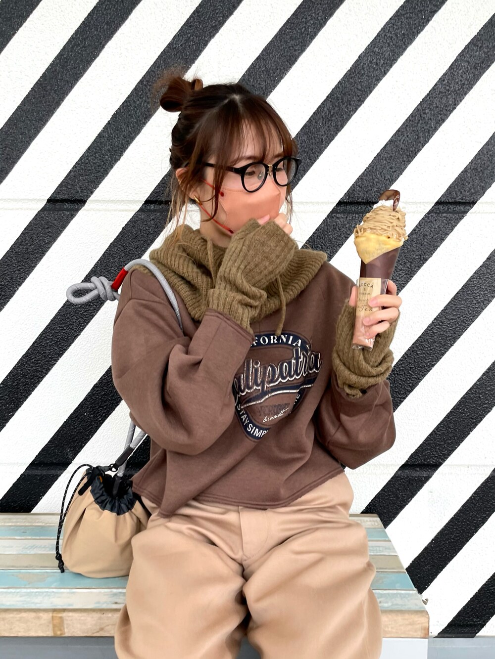 ブラウン系のスウェット、ベージュ系のバッグ、ベージュ系のパンツを着用したレディースの冬コーディネートの3枚目の写真