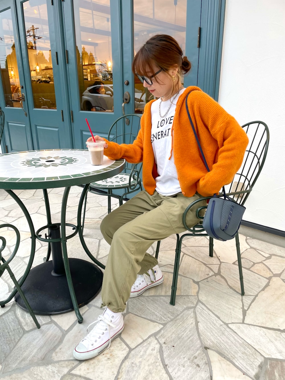 グリーン系のカーゴパンツ、ホワイト系のスニーカー、ホワイト系のTシャツ/カットソーを着用したレディースの秋コーディネートの4枚目の写真