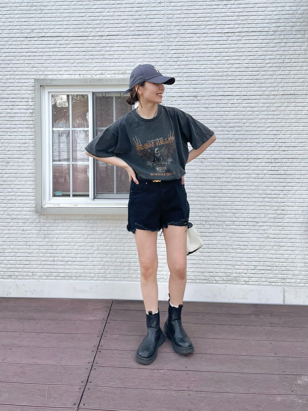 ブラック系のパンツ、ブラック系のTシャツ/カットソー、ブルー系のデニムジャケットを着用したレディースの春コーディネートの2枚目の写真