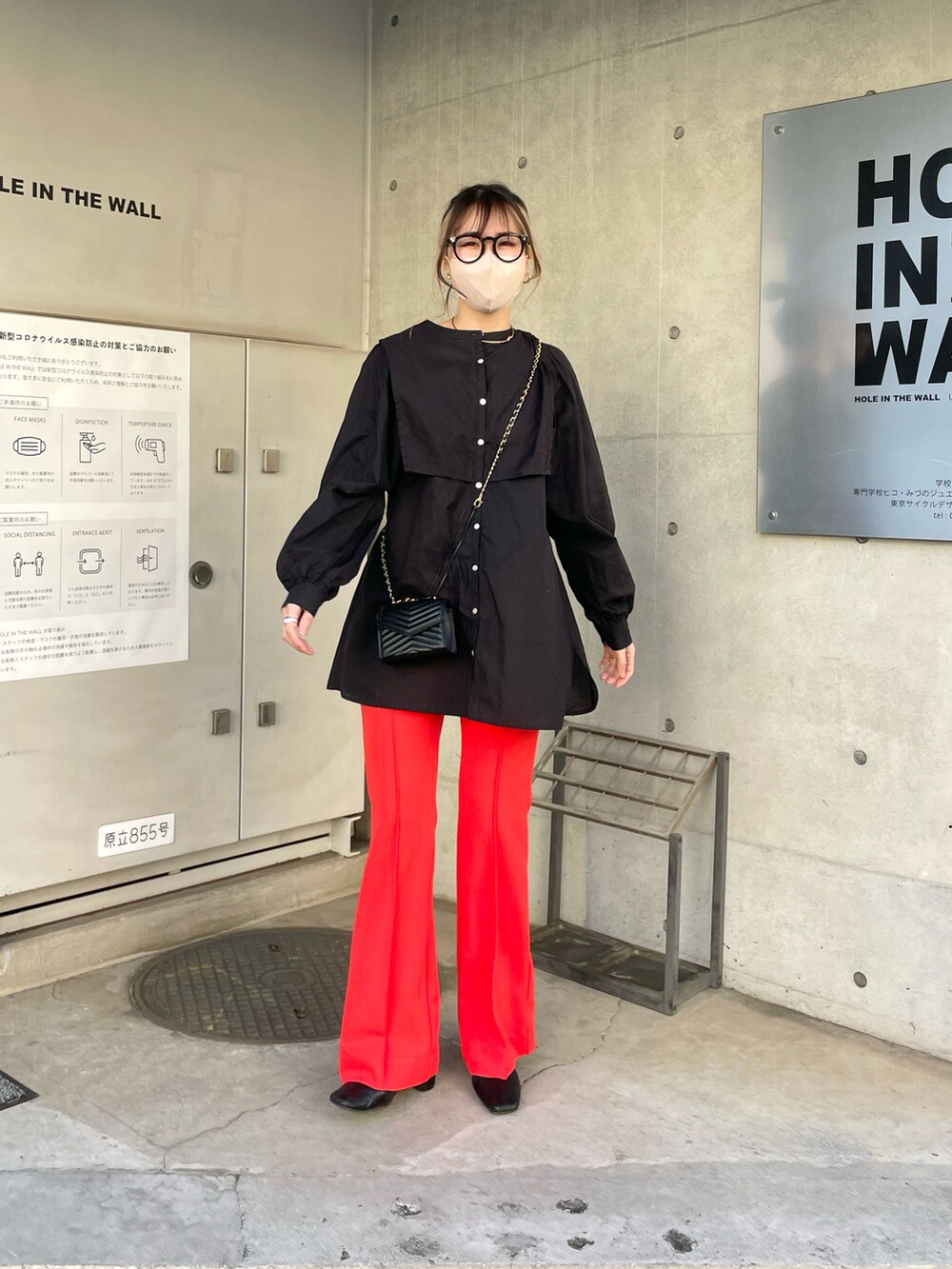 ブラック系のシャツ/ブラウス、オレンジ系のパンツを着用したレディースの春コーディネートの4枚目の写真