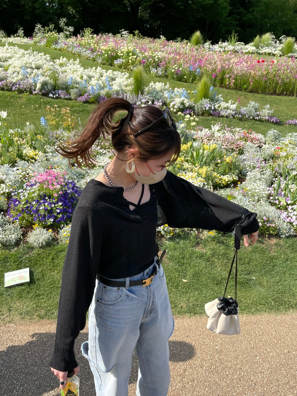 ブルー系のデニムパンツ、ブラック系のトップス、ブラック系のサンダルを着用したレディースの春コーディネートの3枚目の写真