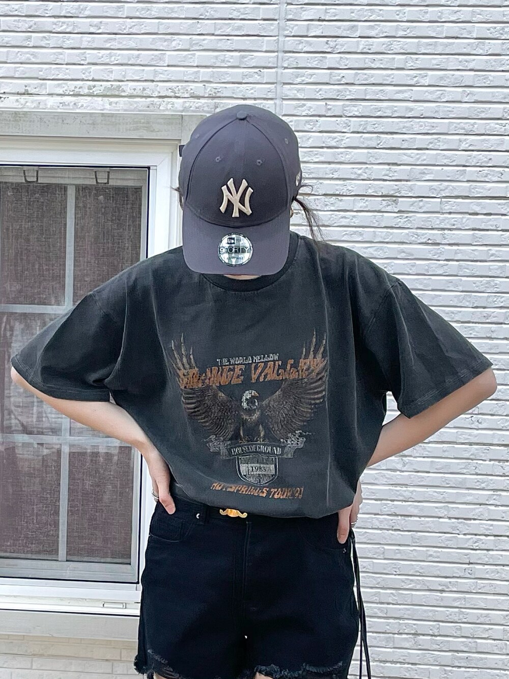 ブラック系のパンツ、ブラック系のTシャツ/カットソー、ブルー系のデニムジャケットを着用したレディースの春コーディネートの3枚目の写真