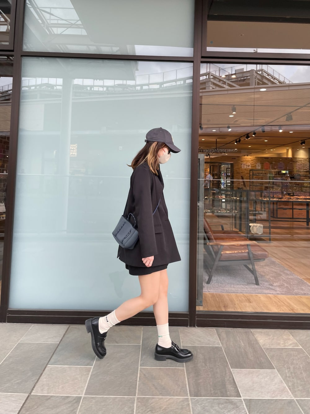 ブラック系のTシャツ/カットソー、ブラック系のスカート、ブラック系のローファーを着用したレディースの春コーディネートの2枚目の写真