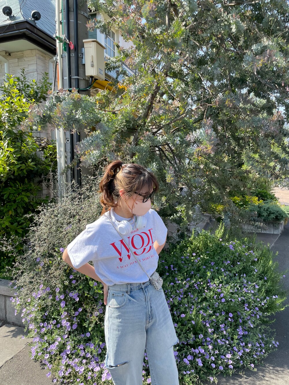 グレー系のTシャツ/カットソー、ブルー系のデニムパンツ、ホワイト系のスニーカーを着用したレディースの春コーディネートの2枚目の写真