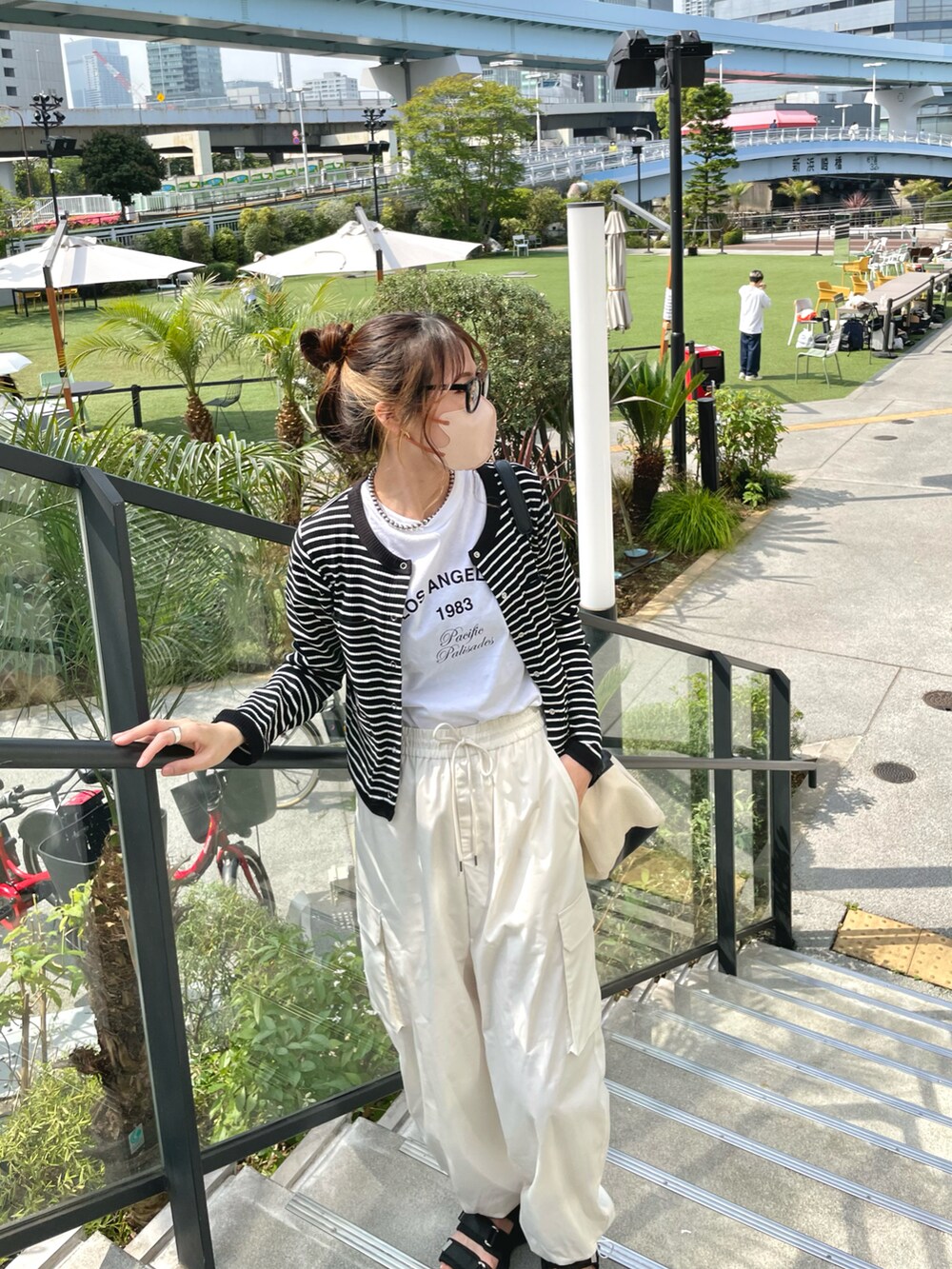 ホワイト系のショルダーバッグ、ホワイト系のTシャツ/カットソー、ブラック系のカーディガン/ボレロを着用したレディースの夏コーディネートの3枚目の写真