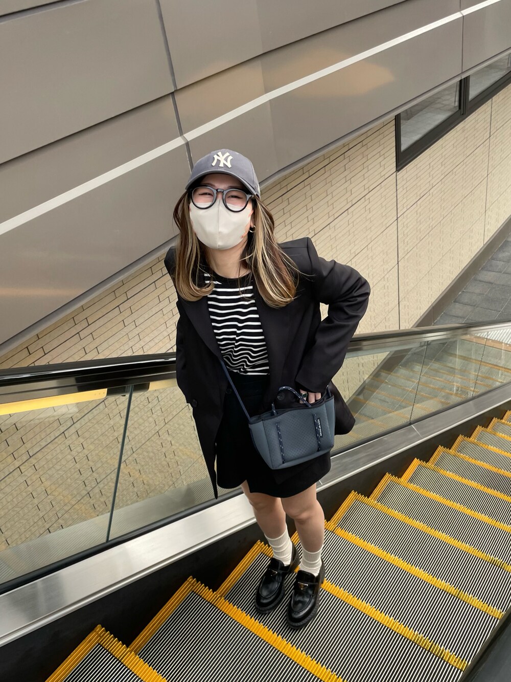 ブラック系のTシャツ/カットソー、ブラック系のスカート、ブラック系のローファーを着用したレディースの春コーディネートの5枚目の写真