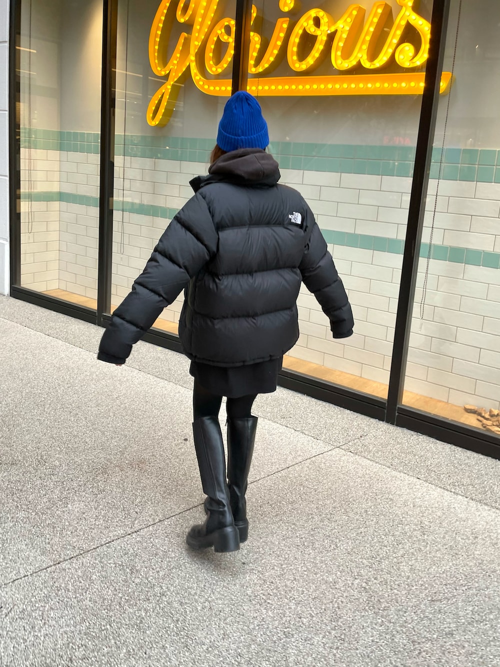 ブラック系のブーツ、ブラック系のダウンジャケット/コート、ブラック系のバッグを着用したレディースの冬コーディネートの2枚目の写真