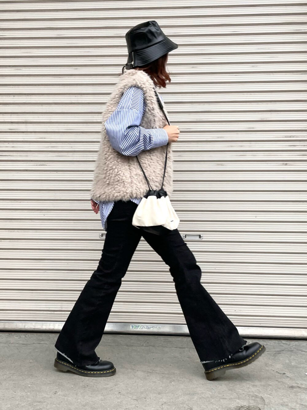 ブルー系のシャツ/ブラウス、ベージュ系のベスト、ブラック系のブーツを着用したレディースの秋コーディネートの2枚目の写真