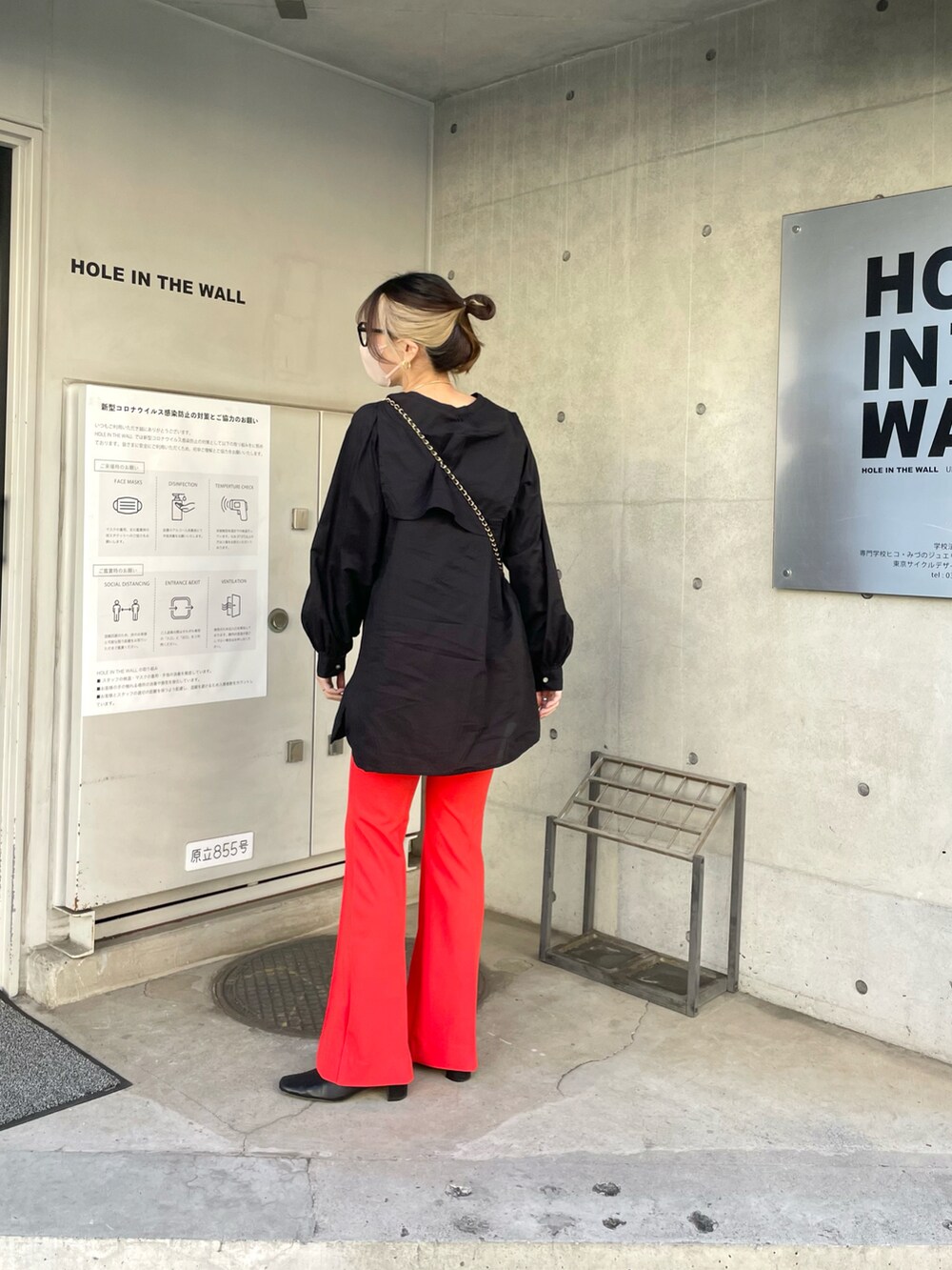 ブラック系のシャツ/ブラウス、オレンジ系のパンツを着用したレディースの春コーディネートの3枚目の写真