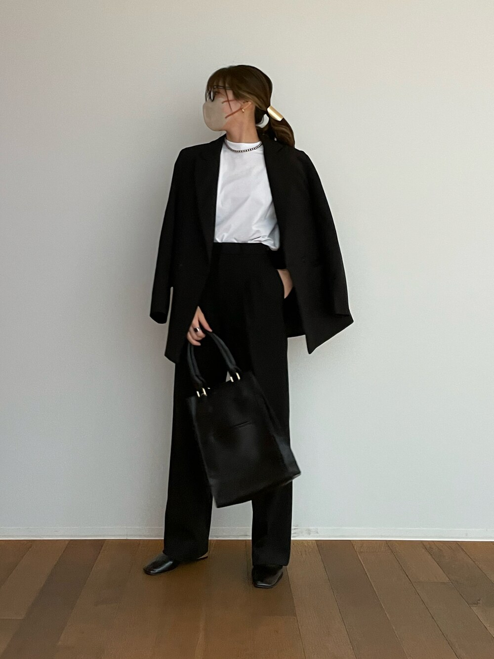 ブラック系のパンツ、ホワイト系のTシャツ/カットソー、ブラック系のパンプスを着用したレディースの春コーディネートの3枚目の写真