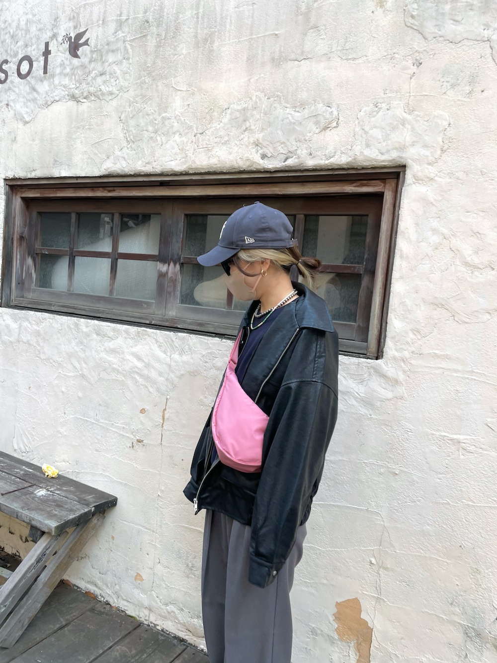 グレー系のパンツ、ピンク系のバッグ、ブラック系のブルゾンを着用したレディースの冬コーディネートの5枚目の写真