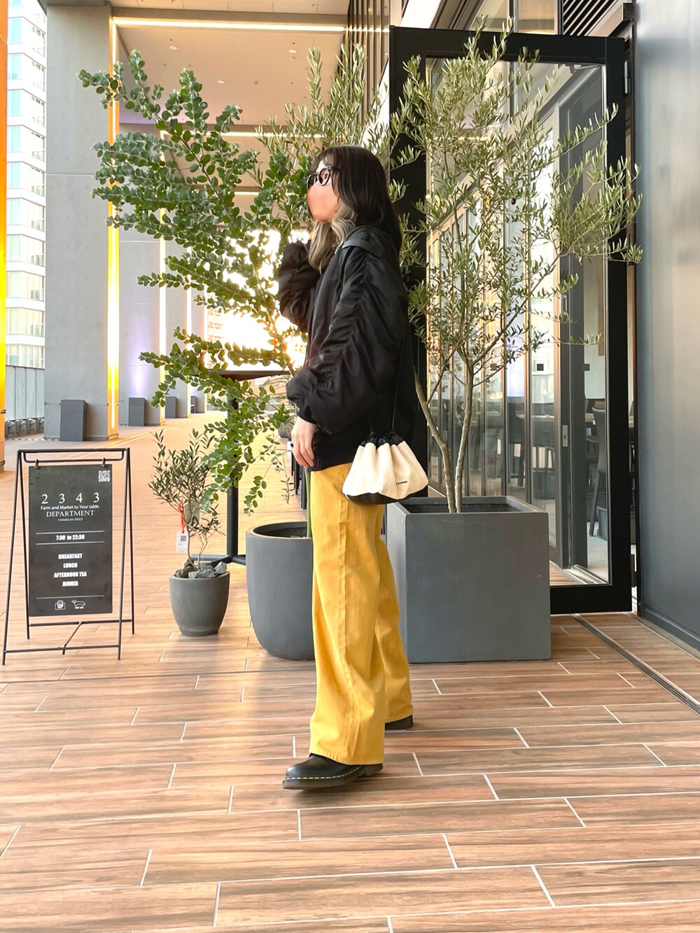 イエロー系のパンツ、ブラック系のMA-1、ブラック系のトップスを着用したレディースの春コーディネートの2枚目の写真