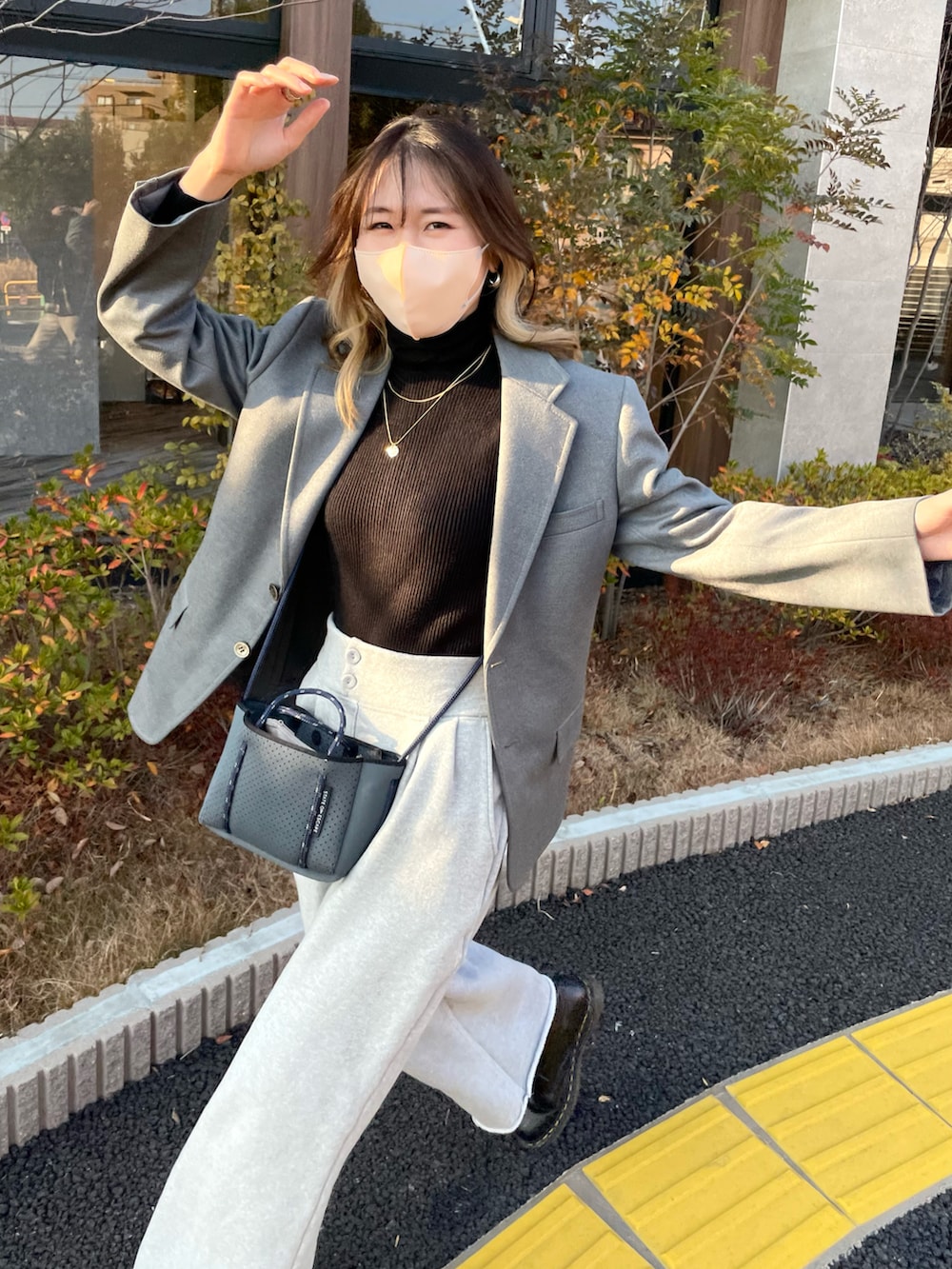 ブラック系のブーツ、ブルー系のバッグ、ブラック系のニット/セーターを着用したレディースの冬コーディネートの2枚目の写真