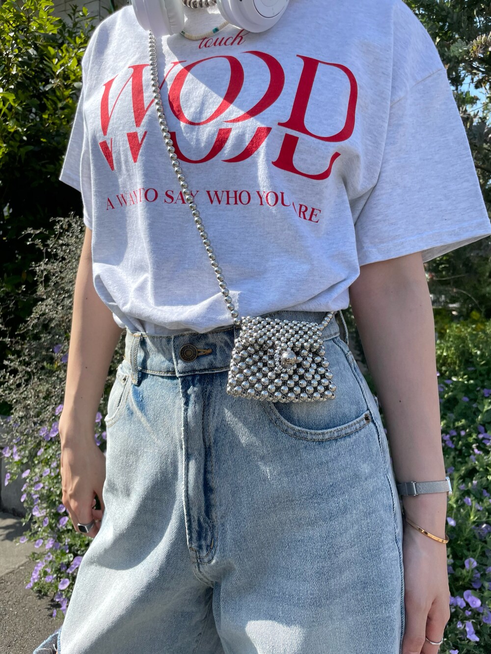 グレー系のTシャツ/カットソー、ブルー系のデニムパンツ、ホワイト系のスニーカーを着用したレディースの春コーディネートの4枚目の写真