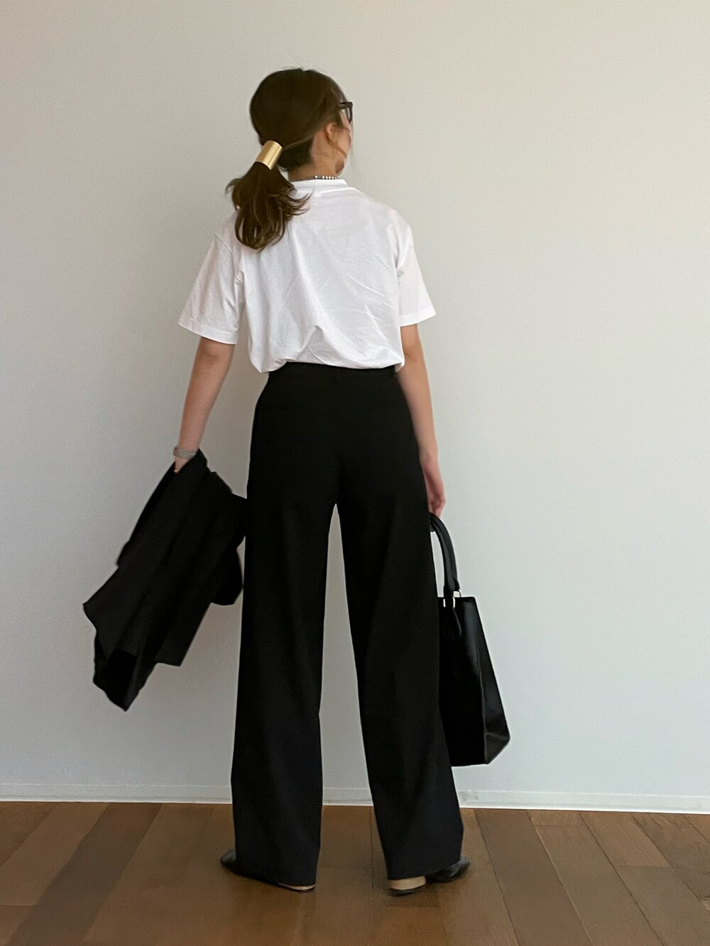ブラック系のパンツ、ホワイト系のTシャツ/カットソー、ブラック系のパンプスを着用したレディースの春コーディネートの4枚目の写真