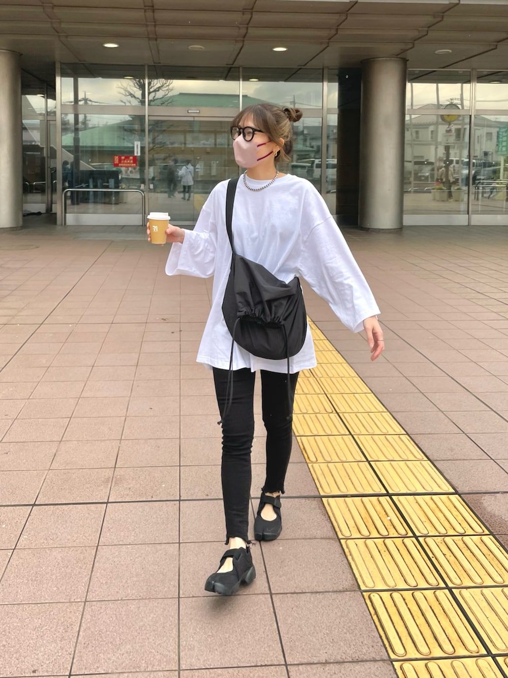 ブラック系のバッグ、ブラック系のサンダル、ホワイト系のTシャツ/カットソーを着用したレディースの春コーディネートの4枚目の写真
