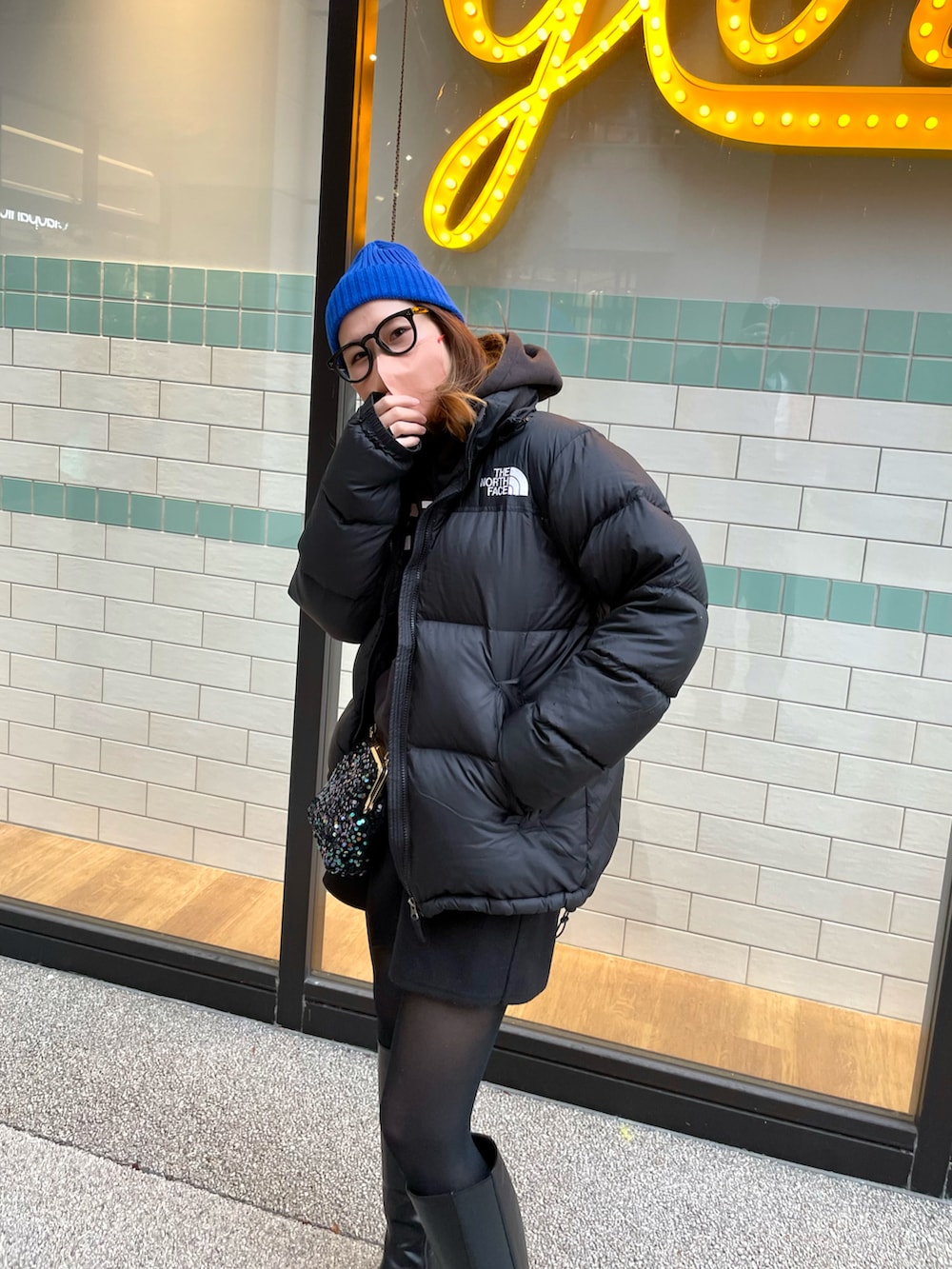 ブラック系のブーツ、ブラック系のダウンジャケット/コート、ブラック系のバッグを着用したレディースの冬コーディネートの3枚目の写真