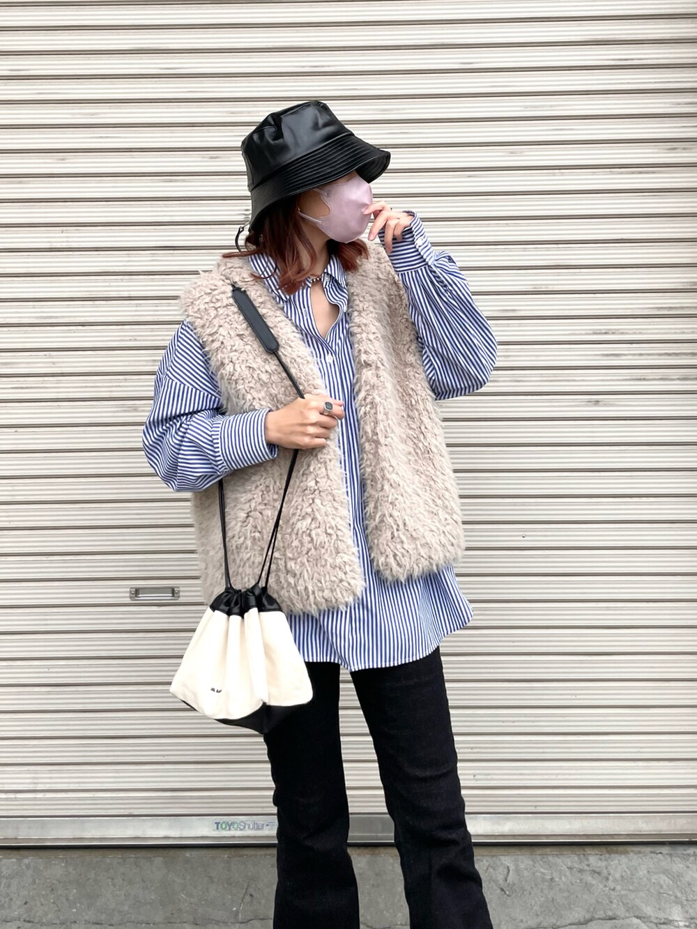 ブルー系のシャツ/ブラウス、ベージュ系のベスト、ブラック系のブーツを着用したレディースの秋コーディネートの4枚目の写真